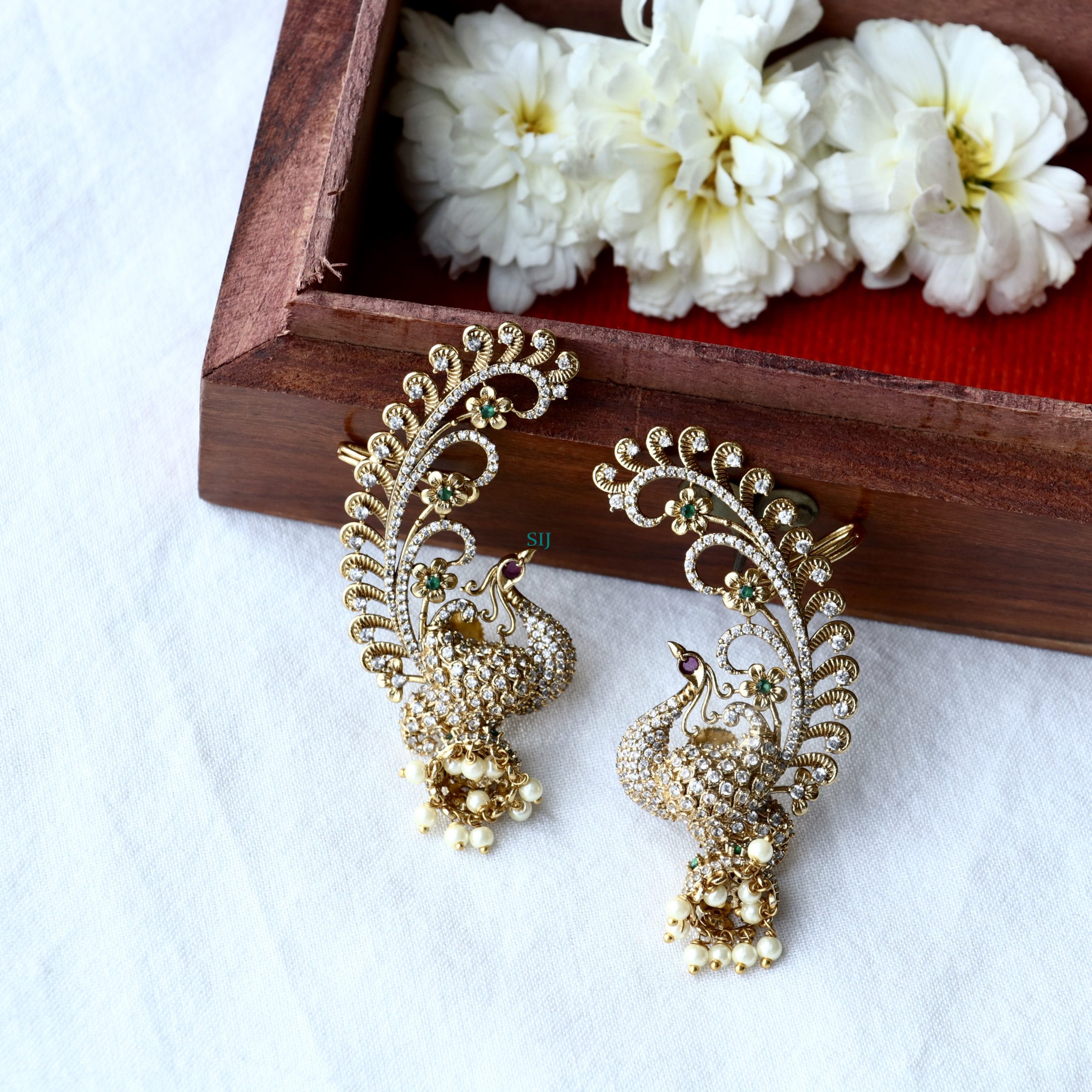 Matte finish flower design earcuff jhumkas embody delicate beauty and modern charm. These earrings feature intricate floral patterns with a matte finish, offering a subtle yet striking allure. The earcuff design adds a contemporary twist, making them a versatile accessory for both casual and formal occasions, enhancing any ensemble with elegance and sophistication.