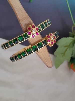 The Jadau Kundan Screw-Type Bangle is a timeless blend of traditional artistry and refined elegance. Crafted with intricate detailing, this exquisite piece showcases the beauty of Kundan stones set using the age-old Jadau technique. The screw-type mechanism ensures a secure yet comfortable fit, making it ideal for regular wear or special occasions. Adorned with rich craftsmanship, the bangle reflects the cultural heritage of Indian jewelry-making. Whether paired with ethnic attire or worn as a statement accessory, it adds a touch of royalty and charm. This bangle is a perfect choice for those who appreciate heritage-inspired, luxurious jewelry with lasting appeal.